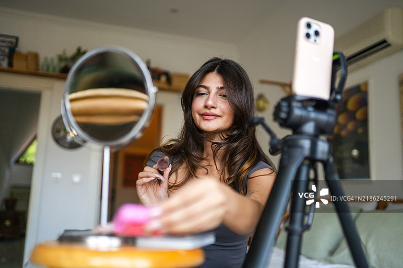 年轻女性与她的粉丝分享她购买的产品图片素材