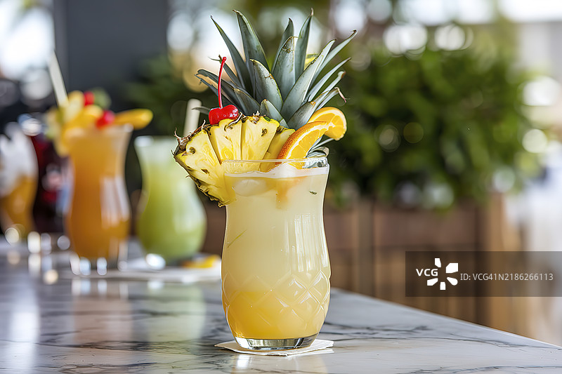 一杯粉色的热带鸡尾酒，上面装饰着一片菠萝和一颗樱桃图片素材