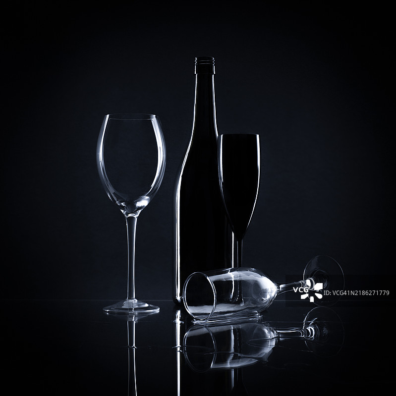 黑色背景下的酒杯和酒瓶特写图片素材