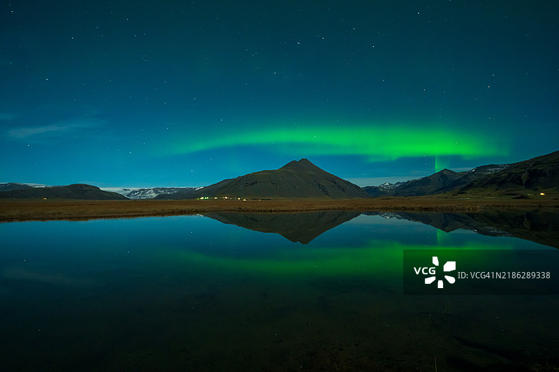极光或北极光，冰岛戏剧性天空中的自然奇观。夜间景观中绿色光芒与冬季白雪交相辉映。图片素材