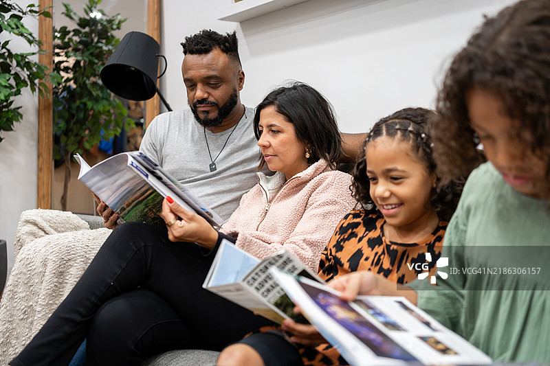 一家人在沙发上选择旅行的最佳行程图片素材