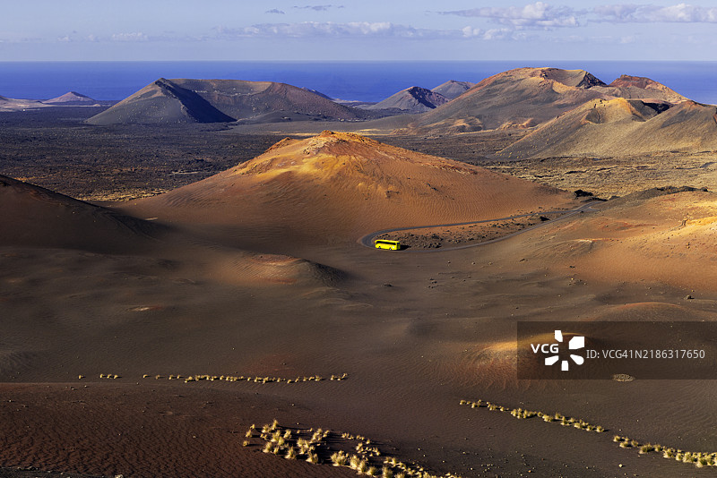 一辆公交车在西班牙加那利群岛兰萨罗特的蒂曼法亚国家公园中间，雅伊萨，蒂纳霍，拉斯帕尔马斯，大西洋，欧洲图片素材