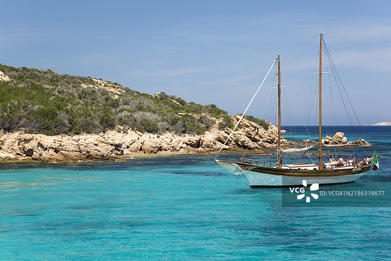 停泊在清澈的绿松石水域中的木帆船，位于意大利撒丁岛拉马达莱纳群岛国家公园的斯帕尔吉岛卡拉格拉纳拉。图片素材