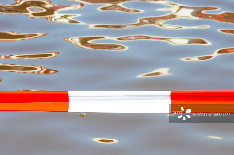 红白相间的警戒带，背景中有水面图片素材