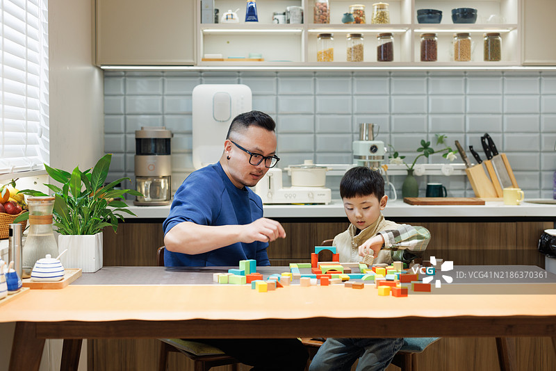 亚洲快乐的父亲和儿子在家里搭积木图片素材