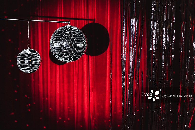 红色天鹅绒背景上的迪斯科球。图片素材