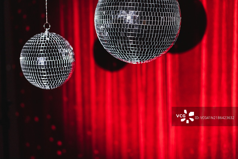 红色天鹅绒背景上的迪斯科球。图片素材