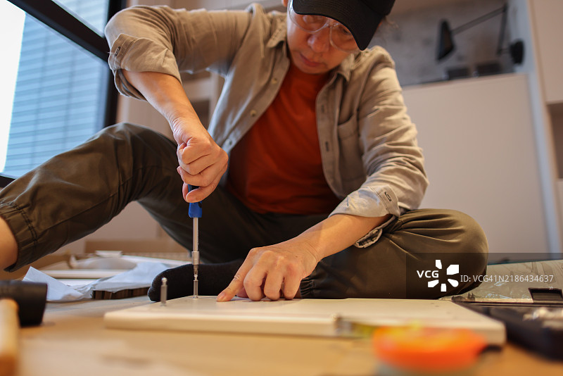 男子在新家组装家具图片素材