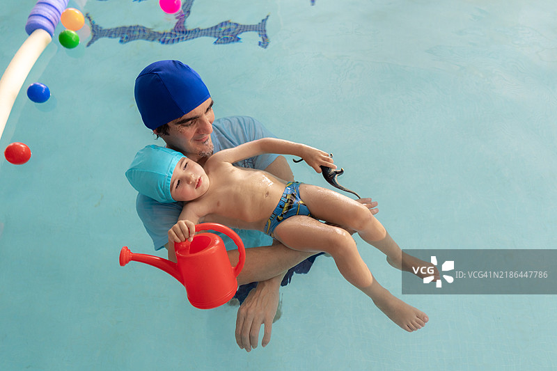 教练在游泳课上抱着一个孩子图片素材