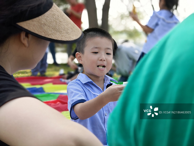 母亲正在给即将外出游玩的孩子们喂食图片素材