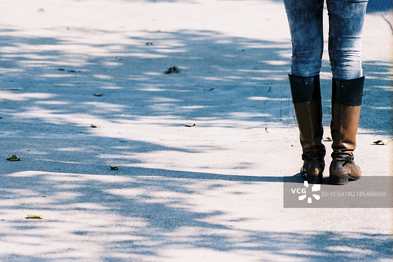 穿着牛仔裤和靴子的女人站在户外图片素材