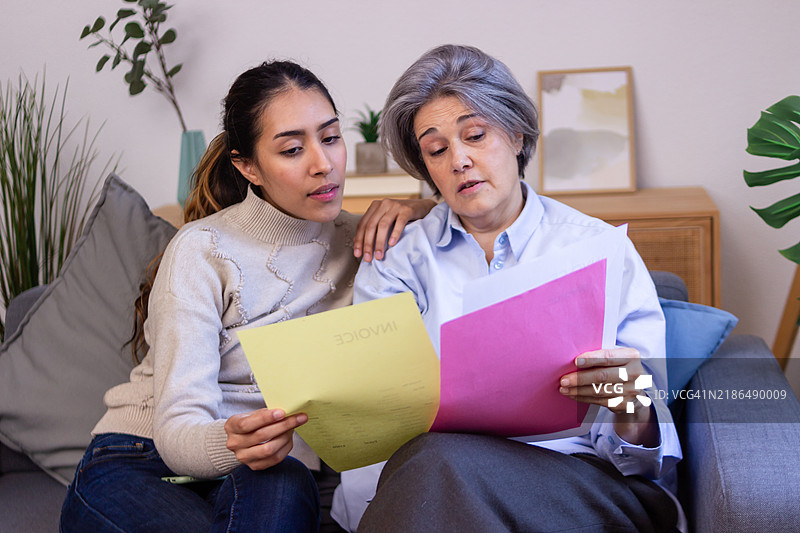 女儿帮助年长母亲处理账单和家庭财务图片素材