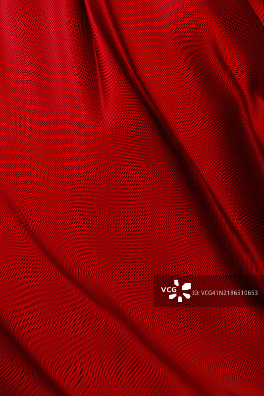 优雅的鲜红色缎面织物特写背景。抽象的纺织纹理，3D图案，垂直构图。设计元素。图片素材