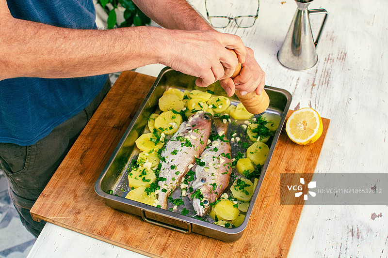 动手烹饪：给新鲜鱼加胡椒图片素材