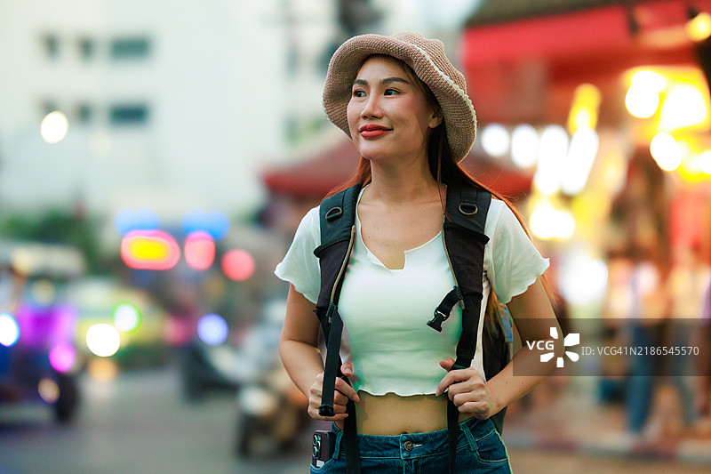 背包客在曼谷热闹的街市中探索，展示了泰国首都的丰富文化、当地商贩和充满活力的街头生活，捕捉了城市冒险和文化探索的精髓。图片素材