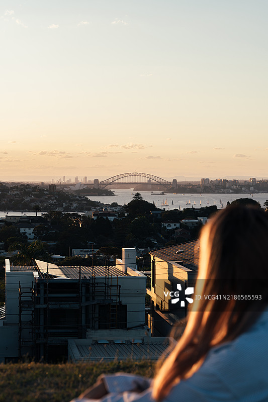 女人在日落时分欣赏悉尼海港大桥图片素材
