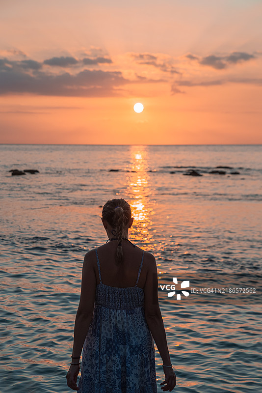 一个无法辨认的女人在森吉吉海滩欣赏日落图片素材