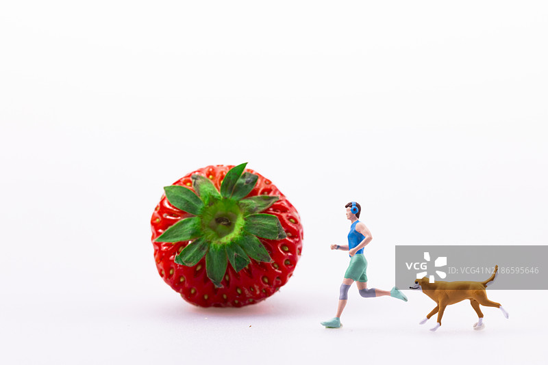 小雕像走过草莓旁边图片素材