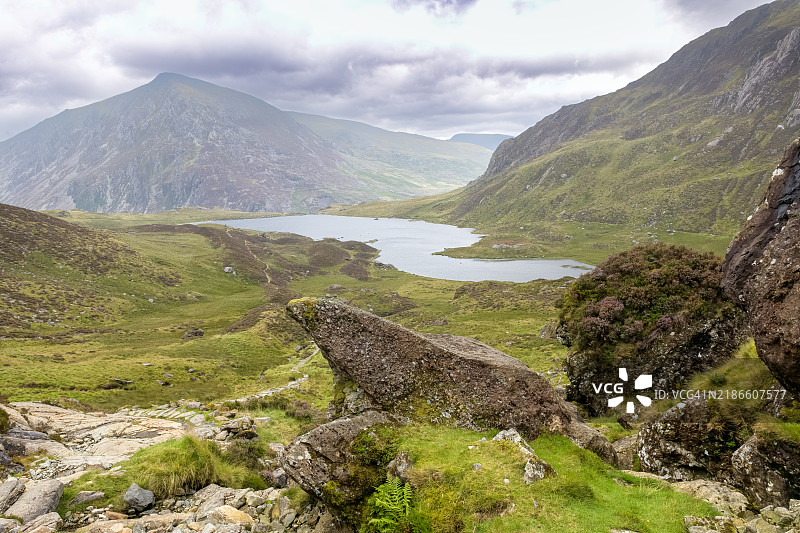 在威尔士环绕伊德瓦尔山谷的崎岖徒步小径上经过达尔文岩石。图片素材