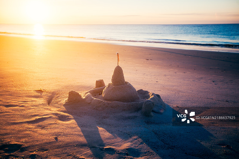 日出时分海滩上的废弃沙堡图片素材