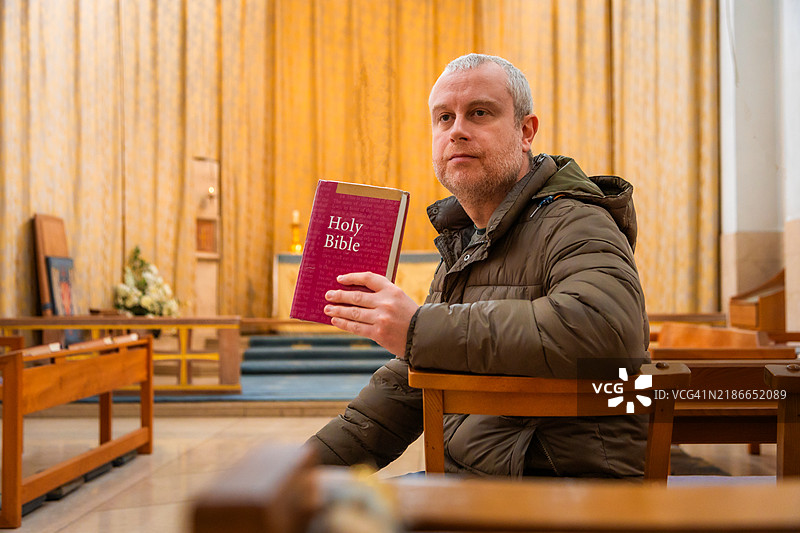在圣公会教堂里阅读圣经的基督教男子图片素材