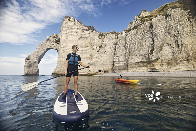 青少年在著名的埃特雷塔悬崖附近划皮划艇和立式划水板图片素材