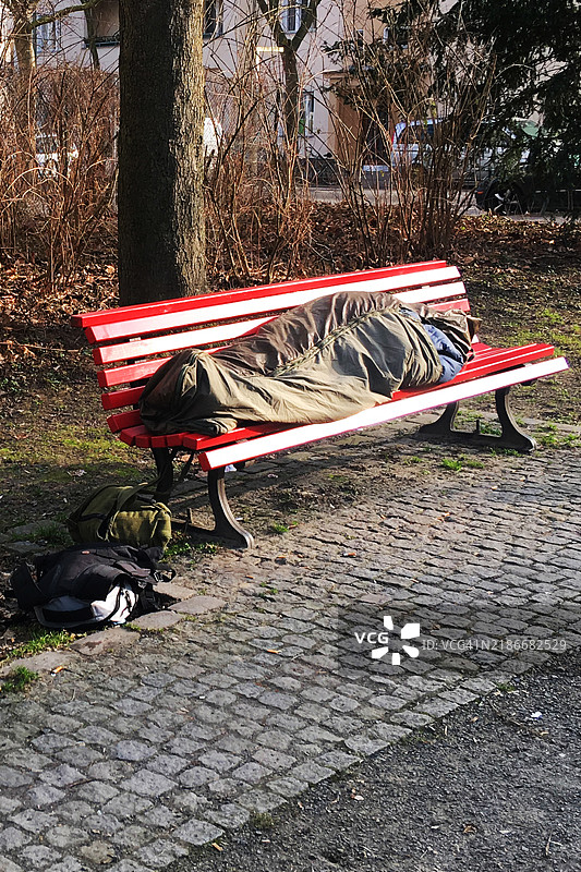 无家可归者在公园长椅上睡觉图片素材