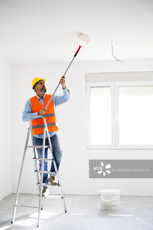 男人在家里粉刷墙壁图片素材