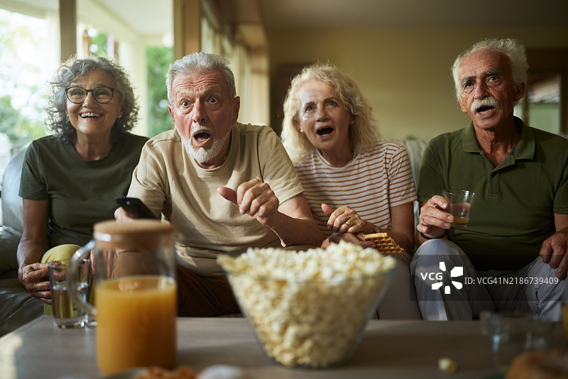 成熟夫妇在养老院里看电视，目瞪口呆地观看电影。图片素材