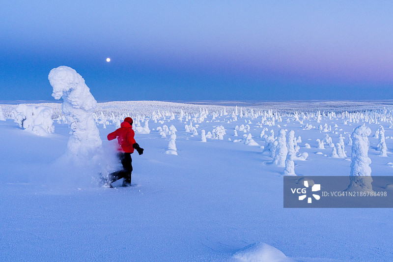 快乐的徒步旅行者在日出时分的深雪中奔跑图片素材