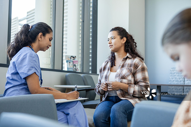 担心的母亲与儿科医生交谈图片素材