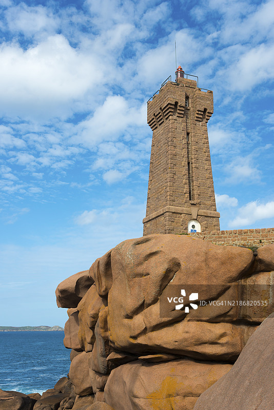 在晴朗的天空下，石质灯塔矗立在岩石之上，位于法国布列塔尼的粉红花岗岩海岸，梅尔鲁兹灯塔，普洛曼纳赫，斯奎维尔角，佩罗吉雷克，粉红花岗岩海岸。图片素材
