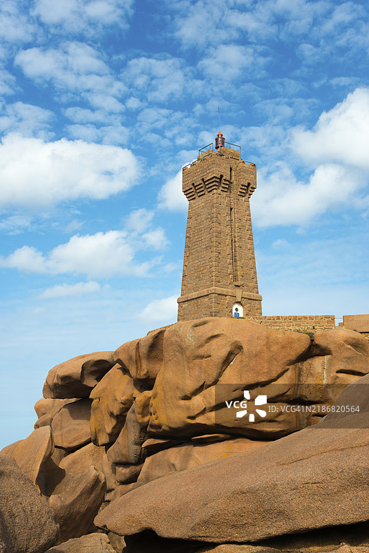 一座灯塔矗立在巨石上，蓝天映衬下的梅尔鲁兹灯塔，普洛曼阿赫，斯奎维尔角，佩罗-吉雷克，粉色花岗岩海岸，粉色花岗岩海岸，布列塔尼，法国，欧洲图片素材