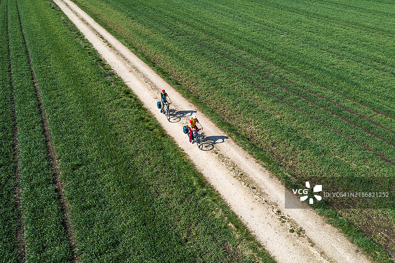 两名骑自行车的人在泥土路上，鸟瞰图图片素材