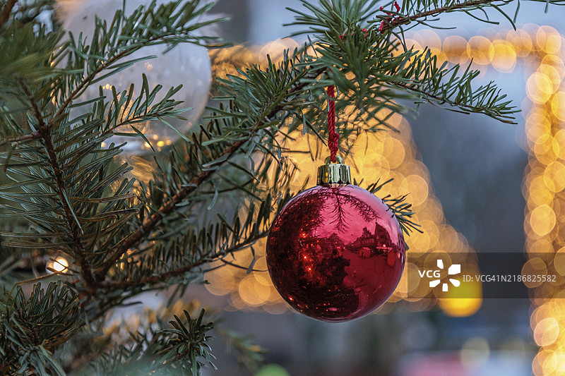 红色圣诞球与背景中的灯光装饰在树上，弗雷登，明斯特兰，德国图片素材
