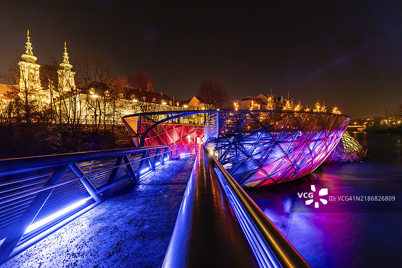 夜景中的照明穆林塞尔，背景是玛丽亚希尔费教堂，奥地利施蒂利亚州格拉茨图片素材