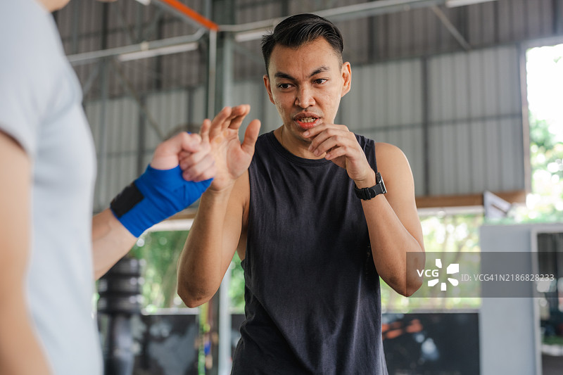 专注的运动：一名男子在健身房进行踢拳训练图片素材