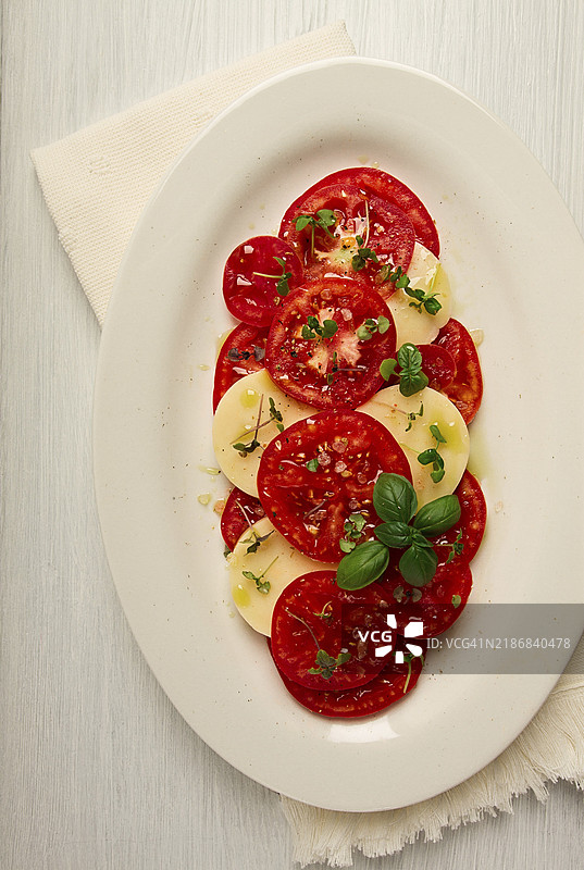 卡普雷塞沙拉，意大利传统菜肴，番茄配马苏里拉奶酪、罗勒和香料，俯视图，无人。图片素材
