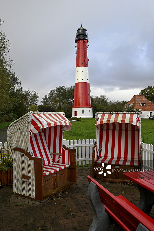 1906年灯塔前的沙滩椅,佩尔沃姆岛,德国北弗里斯兰,施莱斯维希-霍尔斯坦潮间带国家公园,欧洲图片素材