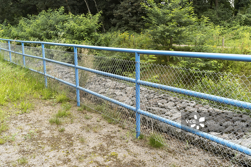 绿色景观中的蓝色金属栏杆图片素材