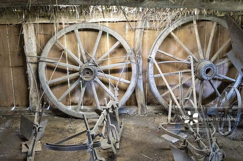 谷仓里的木制辐条轮和犁图片素材