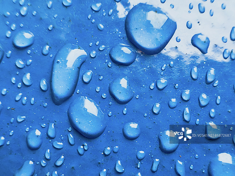 蓝色表面上的水滴特写图片素材