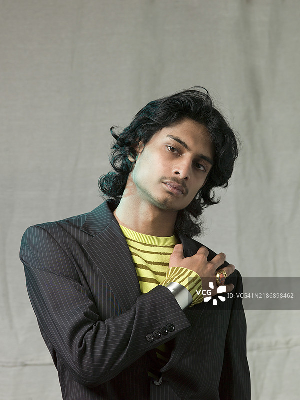 年轻男子穿着独特风格，佩戴着大件珠宝。图片素材