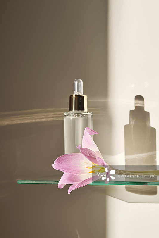 浴室玻璃架上的滴管面部精华液。图片素材