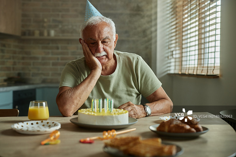 孤独的成熟男性在家庆祝生日。图片素材