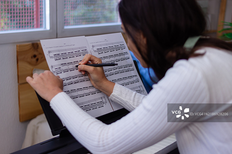 音乐家在钢琴前用钢笔和乐谱创作音乐图片素材