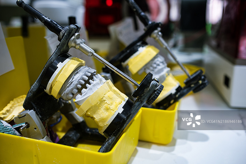 一个新的牙齿模型在石膏模具上进行测量。图片素材