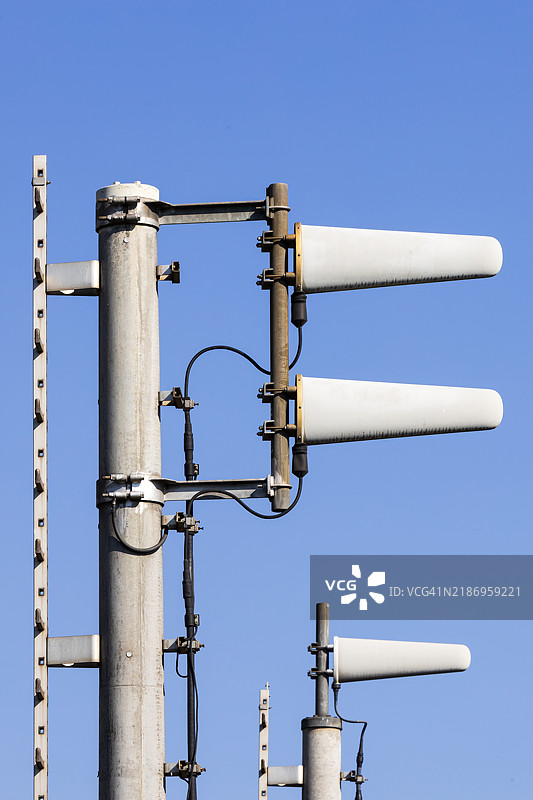 蓝天背景下的手机发射塔上的定向天线图片素材