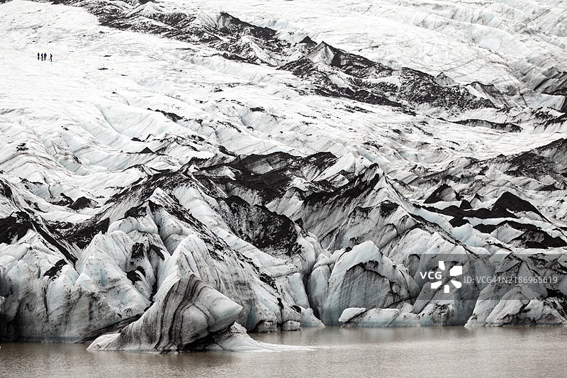 人们在冰岛南部的索尔海马冰川上徒步旅行，俯瞰全景。图片素材