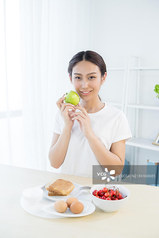 亚洲女性在家享用健康早餐图片素材